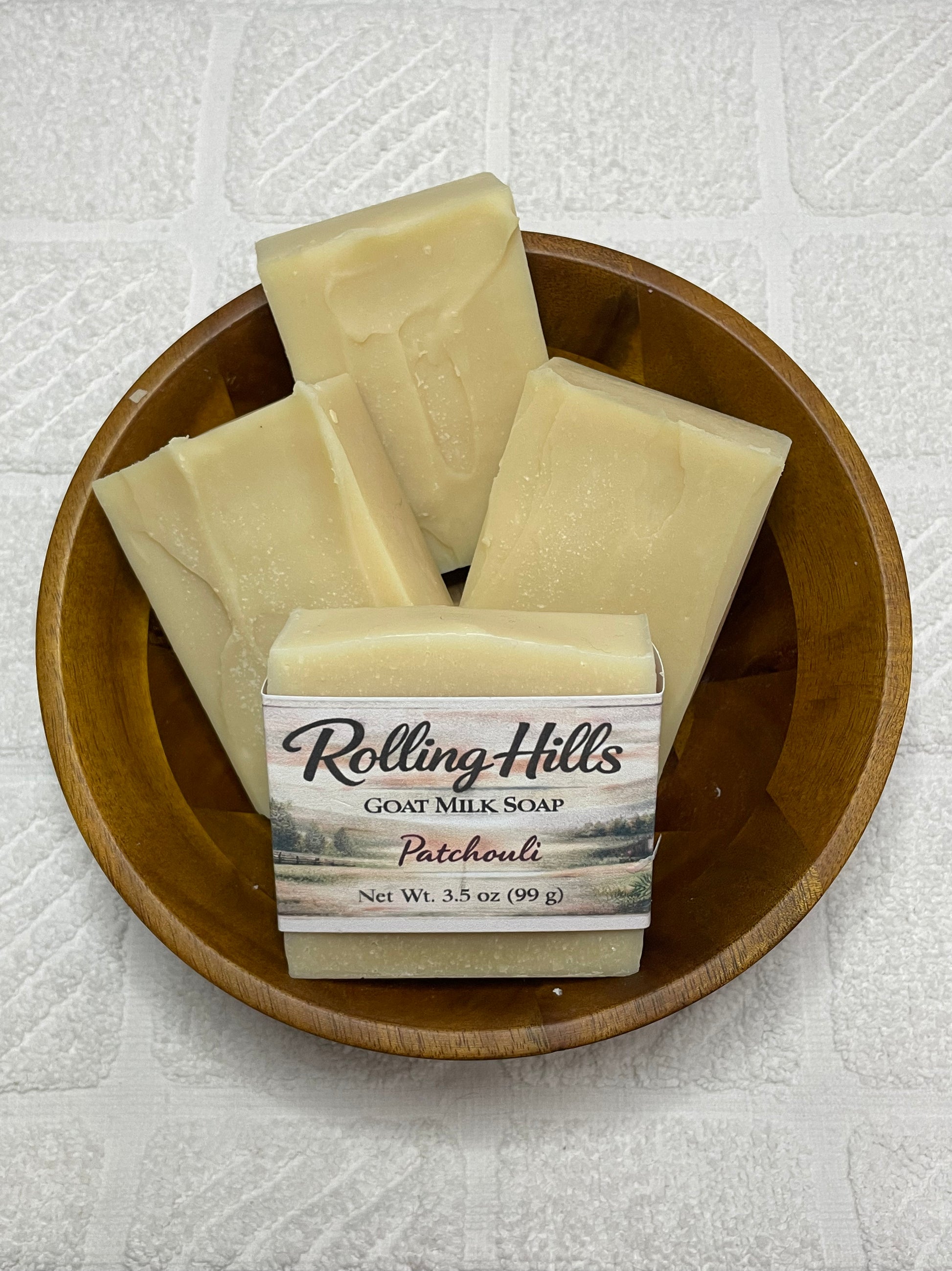 four bars of soap in a wooden bowl with 'Rolling Hills' on a textured white background.