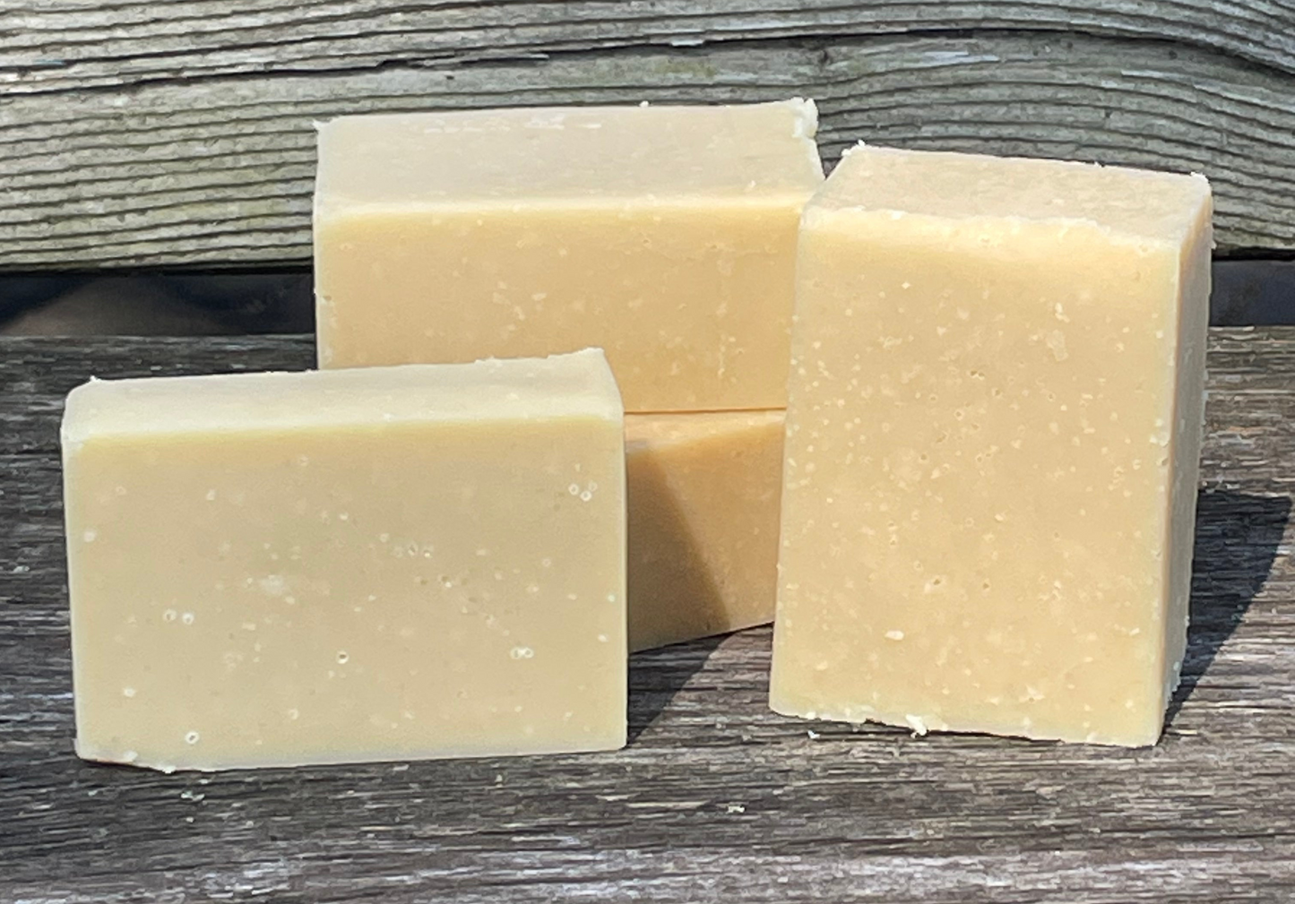 Four bars of soap on a wooden surface