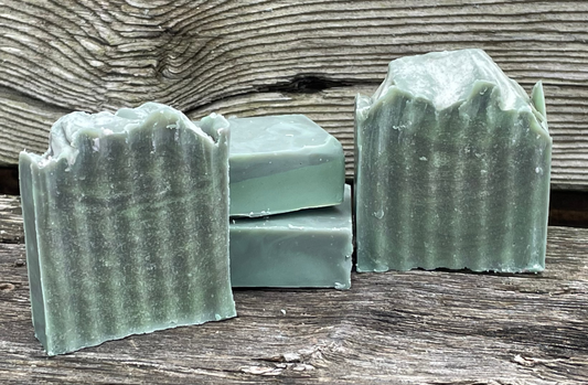 Green soap bars with a wavy texture on a wooden surface