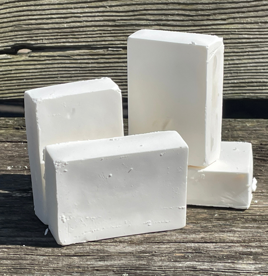 Four bars of castile soap on a wooden bench