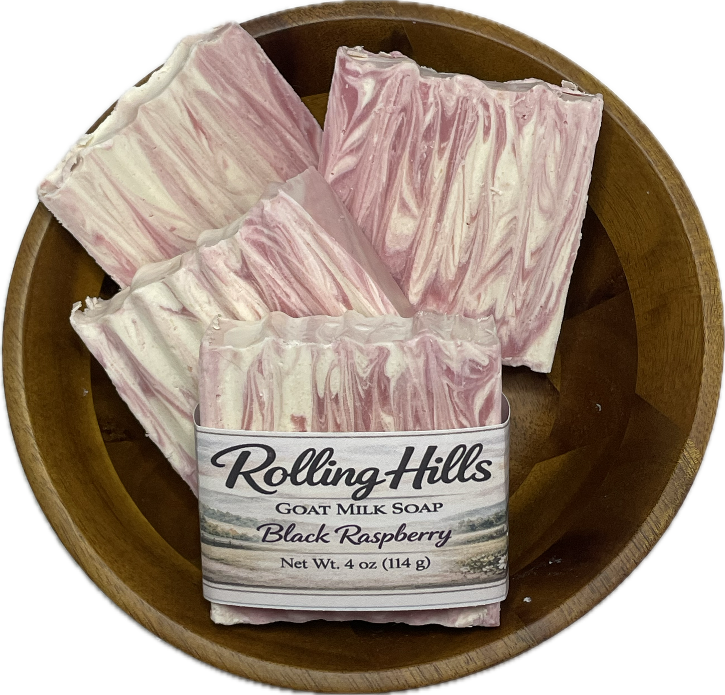 Three bars of Rolling Hills goat milk soap in a wooden bowl on a white background